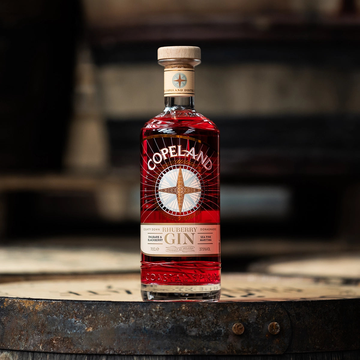 Copeland Rhuberry Gin mit Rhabarber und Brombeere – irischer Gin der Copeland Distillery aus Donaghadee, Flasche auf Whiskyfass